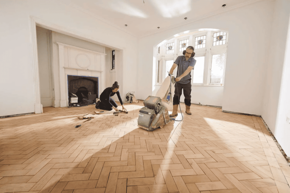 een professioneel die bezig is met uw eiken houten vloer lakken en schuren